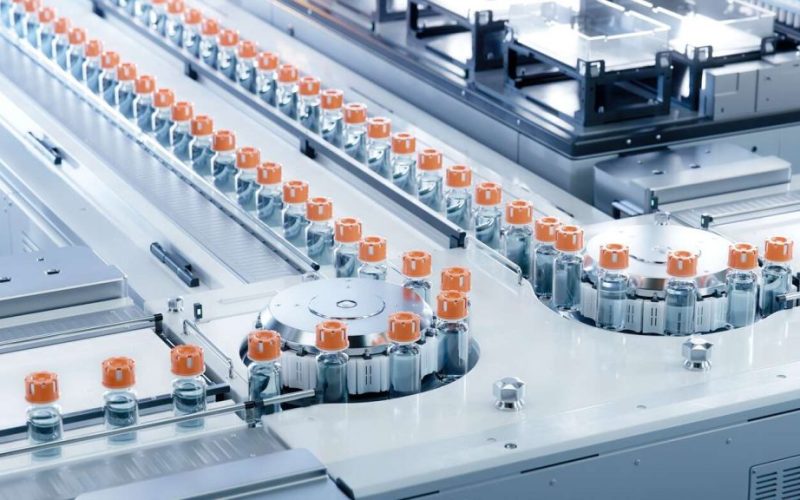 Medication Manufacturing Process. Glass Vials with Orange Caps on Conveyor Belt.